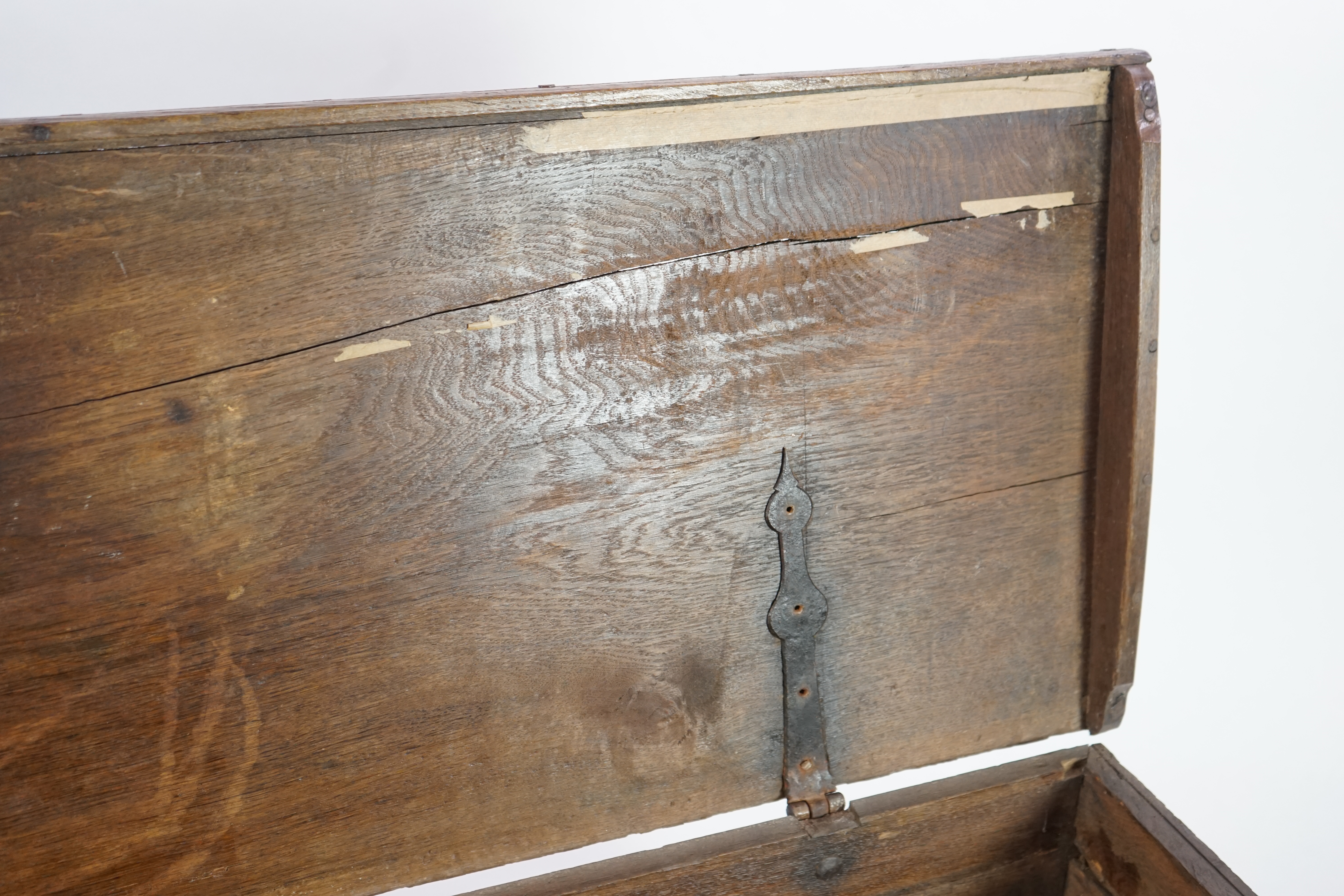 A mid 18th century German carved oak marriage chest, with single planked lid, the frieze, initialled JA/OW and dated 1752, over four arched panels, each with differing foliate motifs and a scroll base panel, width 179cm,